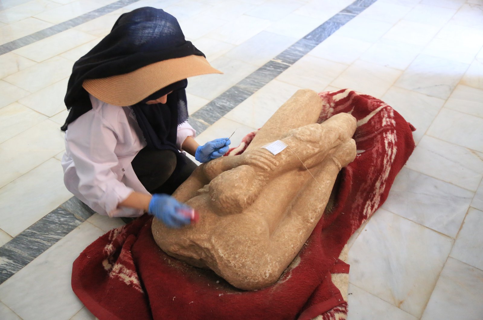 An archaeologist restores a statue unearthed during excavations in the ancient city of Euromos, Muğla, Turkey, July 11, 2021. (AA Photo)