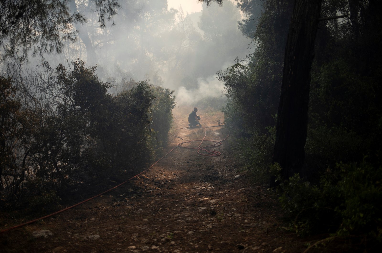 A firefighter pauses as he tries to extinguish a fire burning in the village of Mazi, near Corinth, Greece, May 20, 2021. (Reuters Photo)