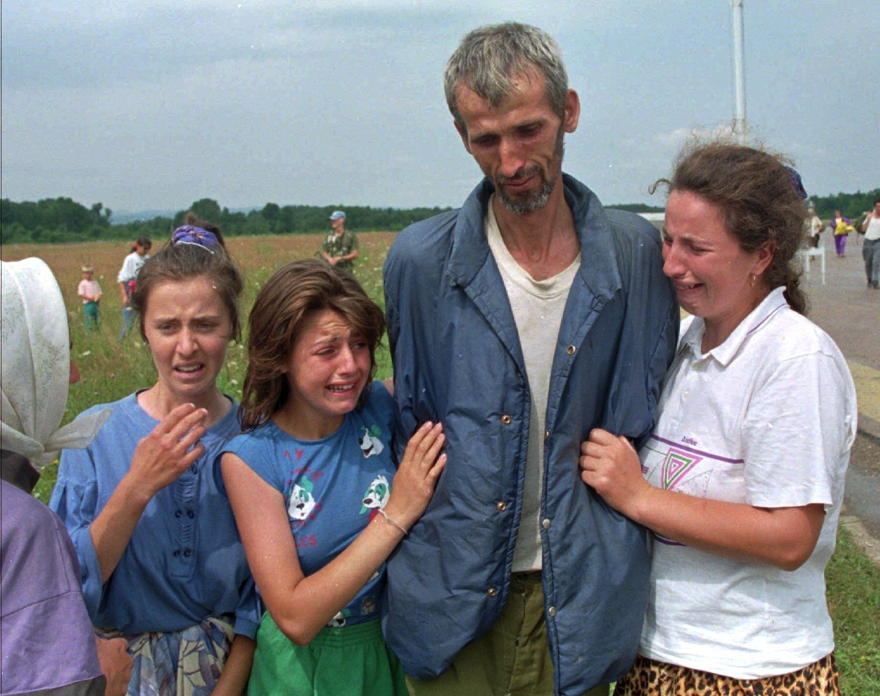 Bosnian refugees cry as their father and husband arrives at the U.N. air base in Tuzla, Bosnia and Herzegovina, after he survived the death march of six days from Srebrenica, July 17, 1995. (AP Photo)