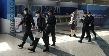 Police walk past the Tokyo 2020 banners as they prepare for a security check at the main press center of the 2020 Summer Olympics, in Tokyo, Japan, July 12, 2021. (AP Photo)