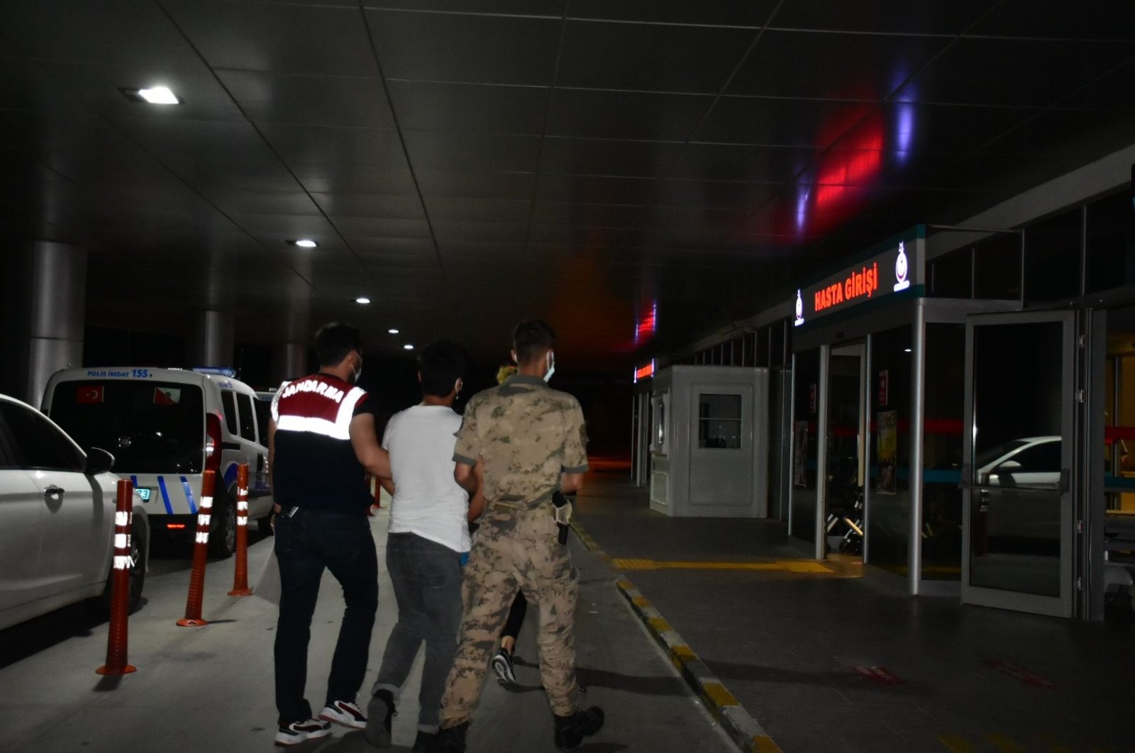 Gendarmerie officers escort a suspect to the hospital for medical checks, in Izmir, western Turkey, July 12, 2021. (DHA PHOTO)