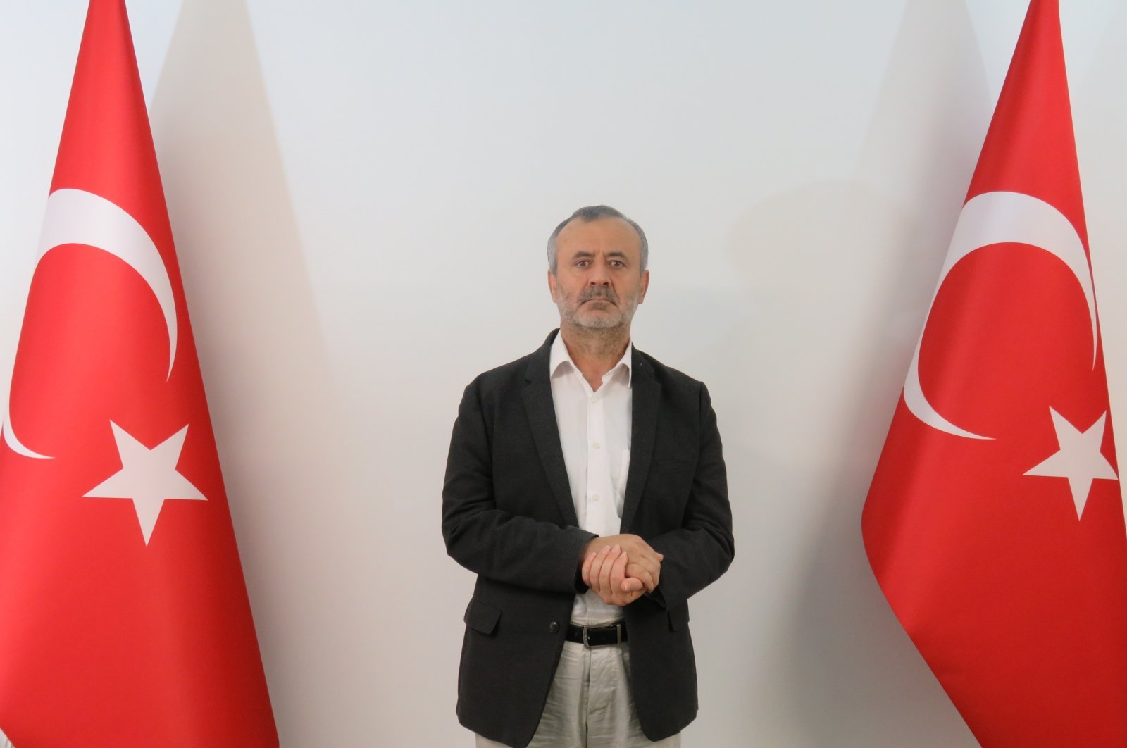 Orhan Inandı poses between two Turkish flags in this photo handed out to the media after he was brought to Turkey, July 5, 2021. (AA Photo)