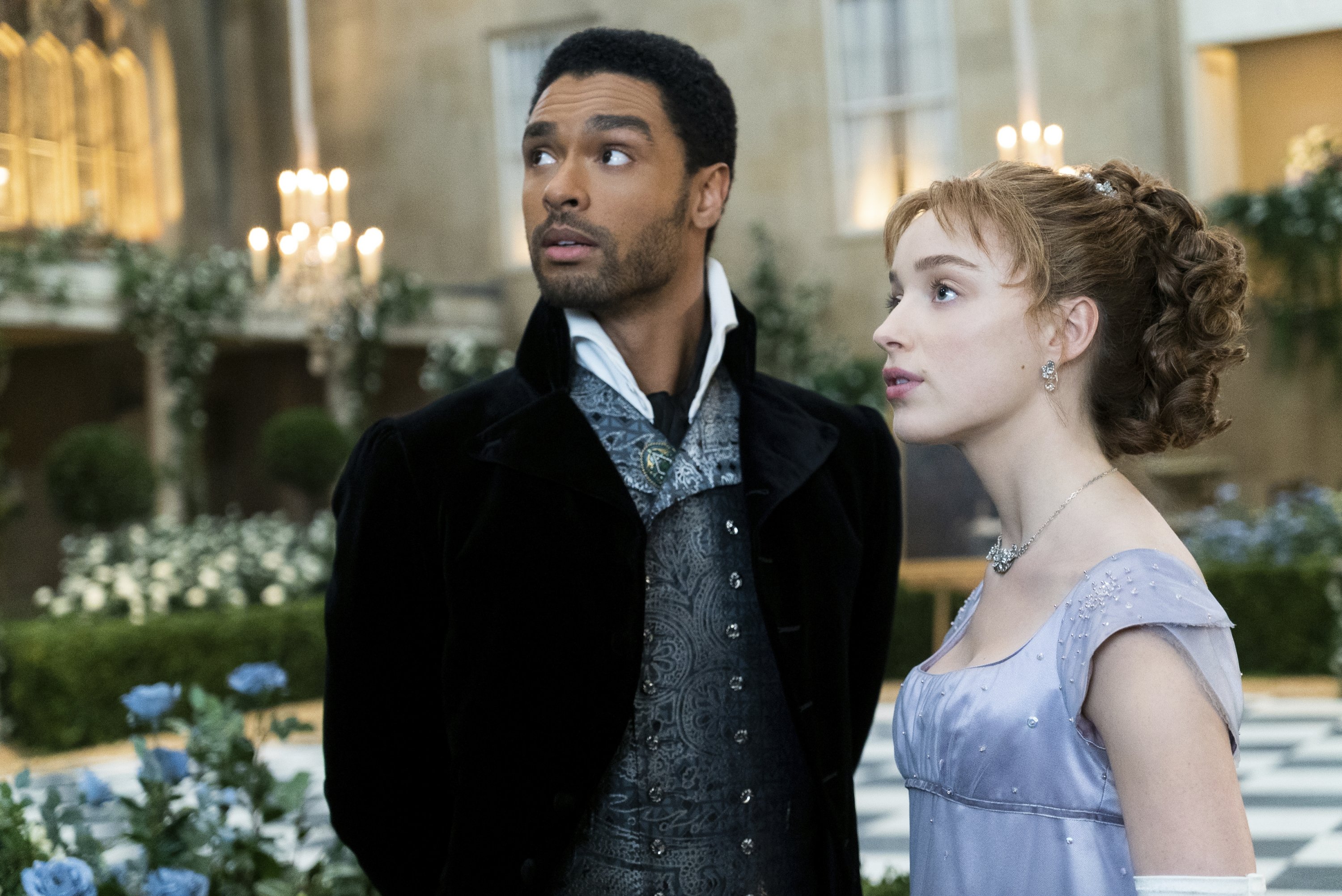This image released by Netflix shows Phoebe Dynevor, right, and Rege-Jean Page in a scene from 'Bridgerton.' (Netflix via AP)