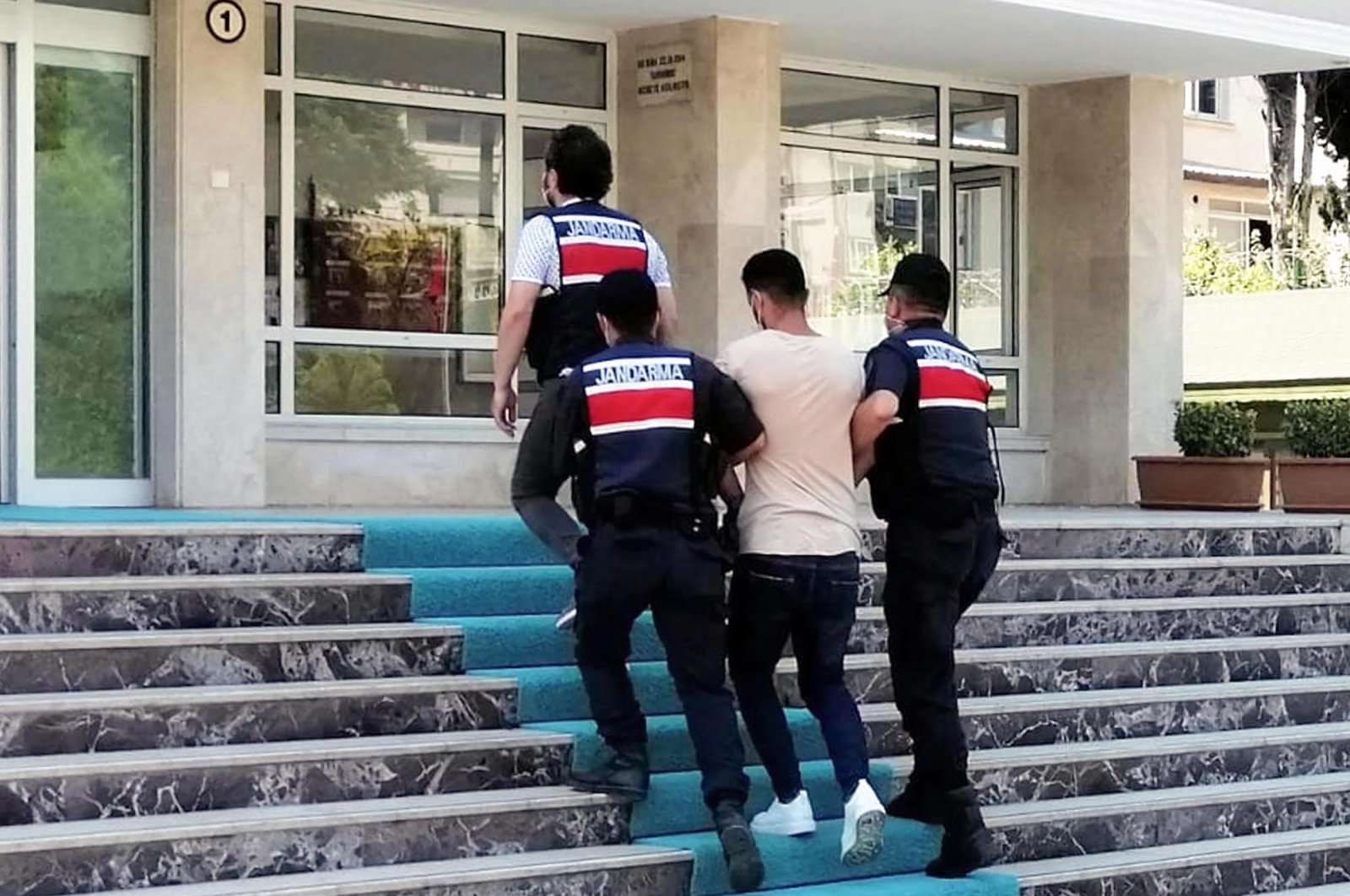 Gendarmerie forces escort a suspected Daesh terrorist to the gendarmerie command in Turkey's southern Mersin province, July 12, 2021. (IHA Photo)