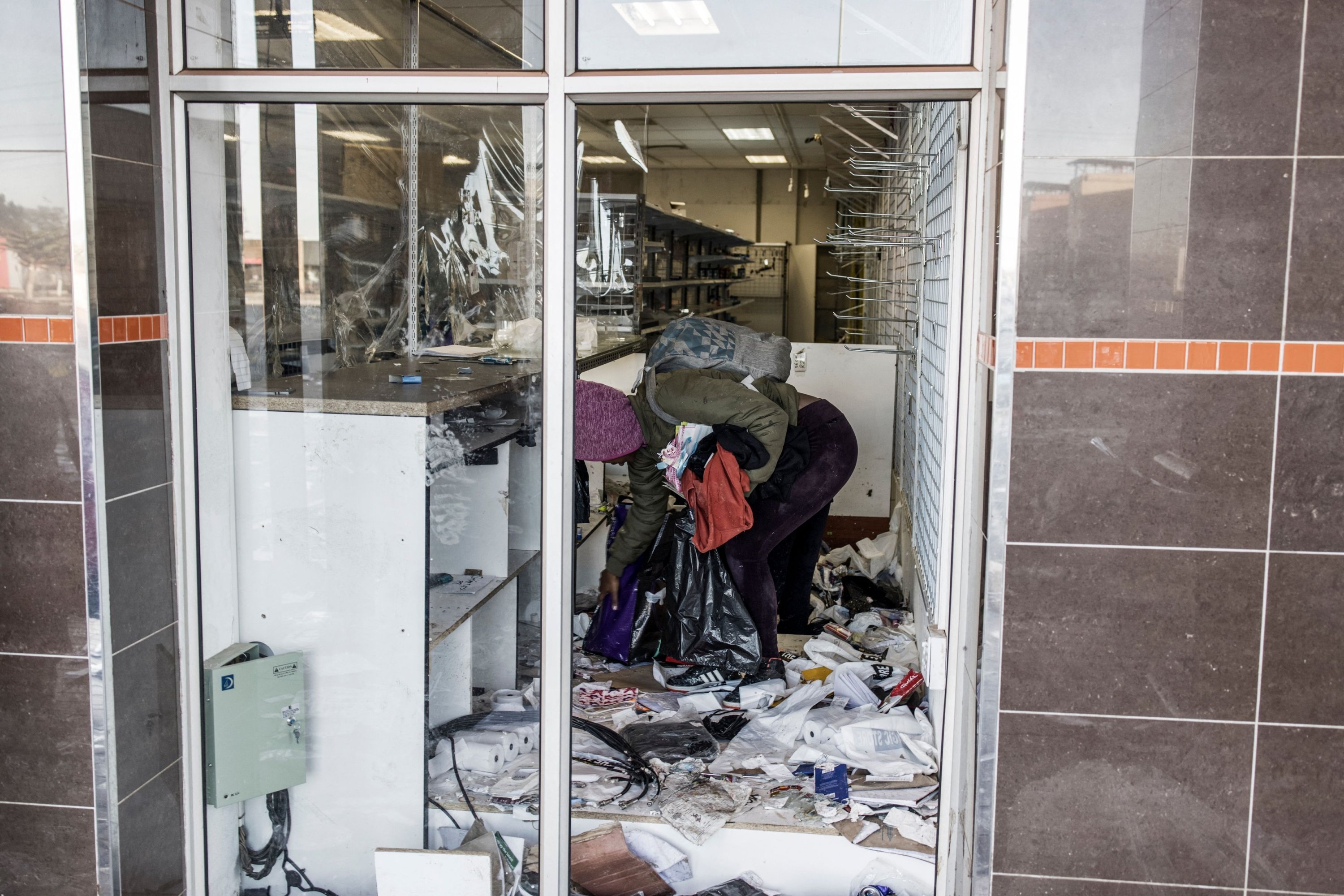 A looter takes away the few items left to grab in a vandalized mall in Vosloorus, South Africa, July 14, 2021. (AFP Photo)
