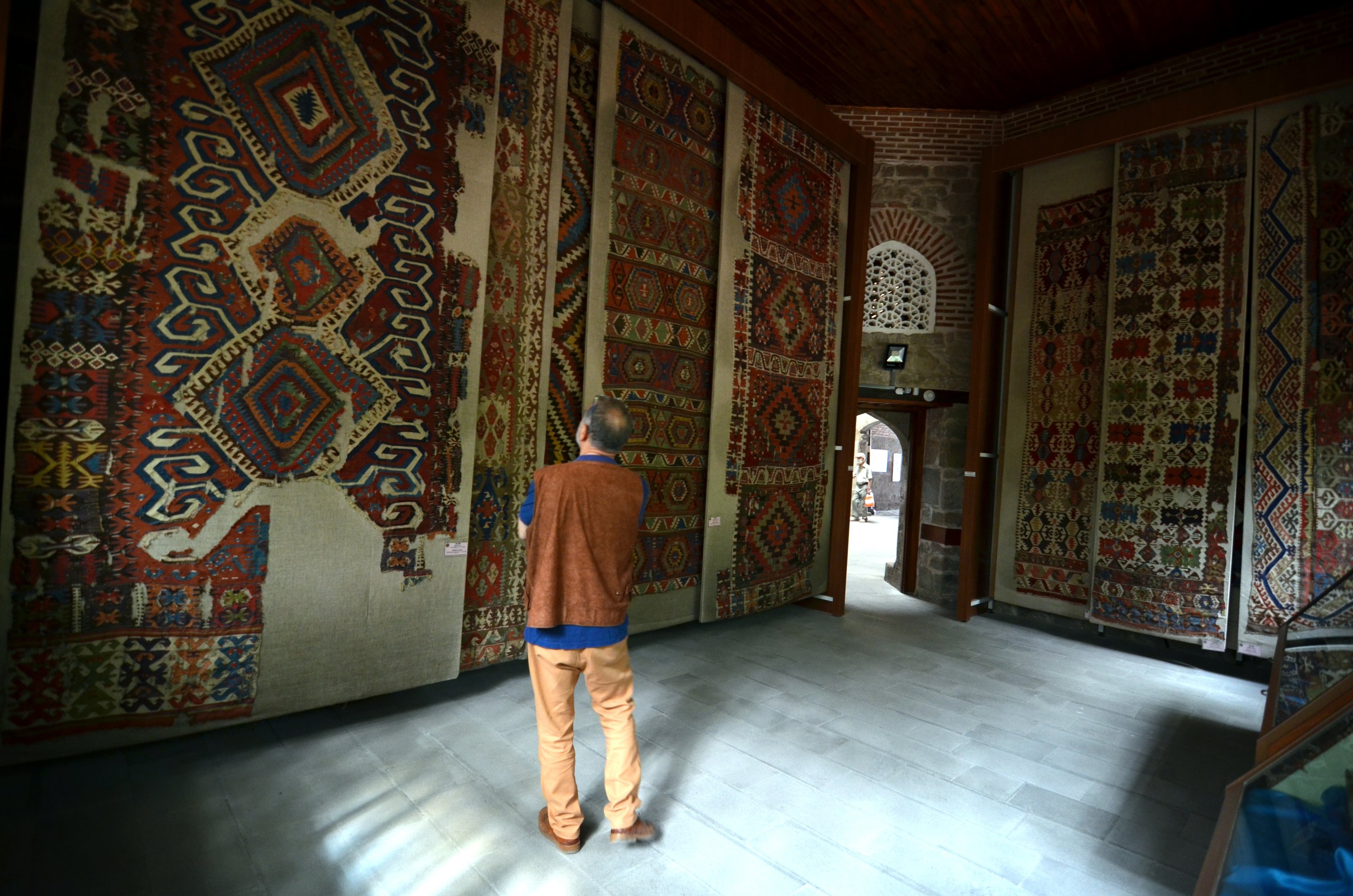 A visitor examines rugs in the Sahip Ata Mosque, Konya, central Turkey, July 11, 2021. (AA Photo)