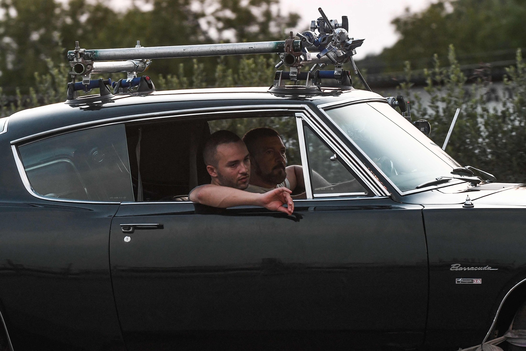 El actor, director y productor español Antonio Banderas (atrás) conduce un automóvil, con un miembro del equipo durante el rodaje del thriller, The Enforcer, en la carretera de circunvalación de Salónica, Grecia, el 30 de junio de 2021 (AFP Photo)