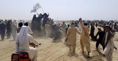 Supporters of the Taliban carry the Taliban's signature white flags in the Afghan-Pakistan border town of Chaman, Pakistan, July 14, 2021. (AP Photo)
