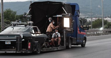 Film crew members work during the filming of the action thriller, "The Enforcer," starring Spanish actor, film director and producer Antonio Banderas, in the ring road of Thessaloniki, Greece, June 30, 2021. (AFP Photo)