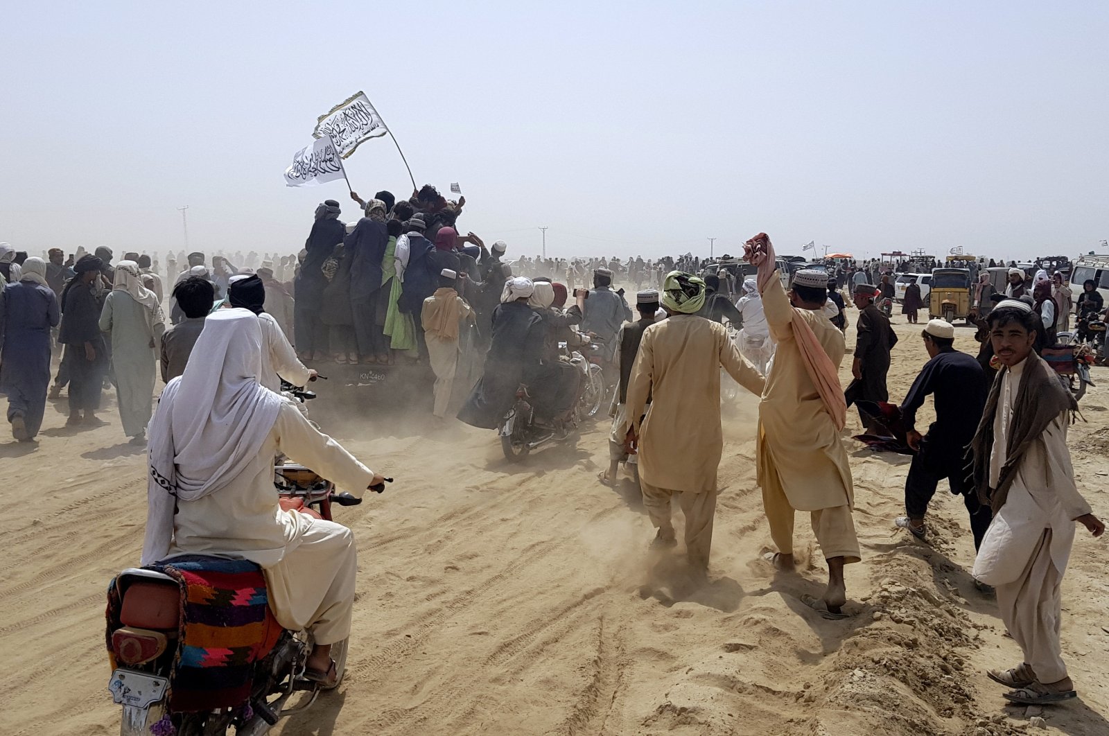 Supporters of the Taliban carry the Taliban's signature white flags in the Afghan-Pakistan border town of Chaman, Pakistan, July 14, 2021. (AP Photo)