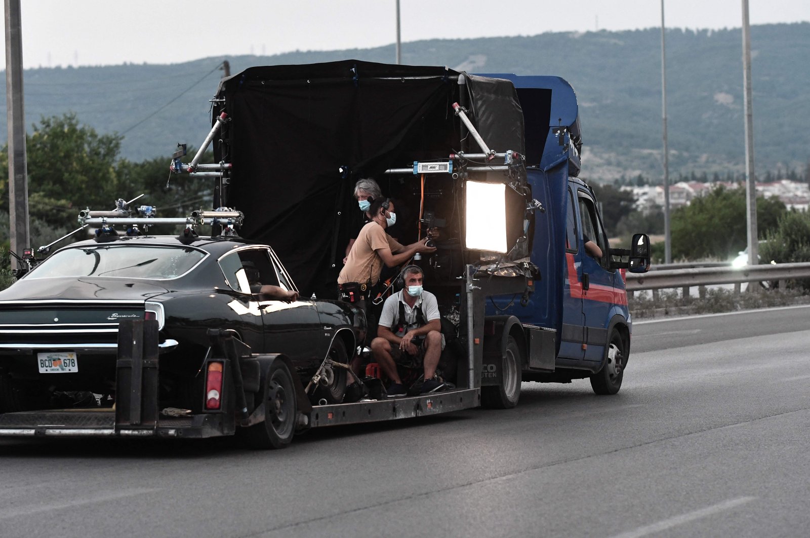 Film crew members work during the filming of the action thriller, "The Enforcer," starring Spanish actor, film director and producer Antonio Banderas, in the ring road of Thessaloniki, Greece, June 30, 2021. (AFP Photo)
