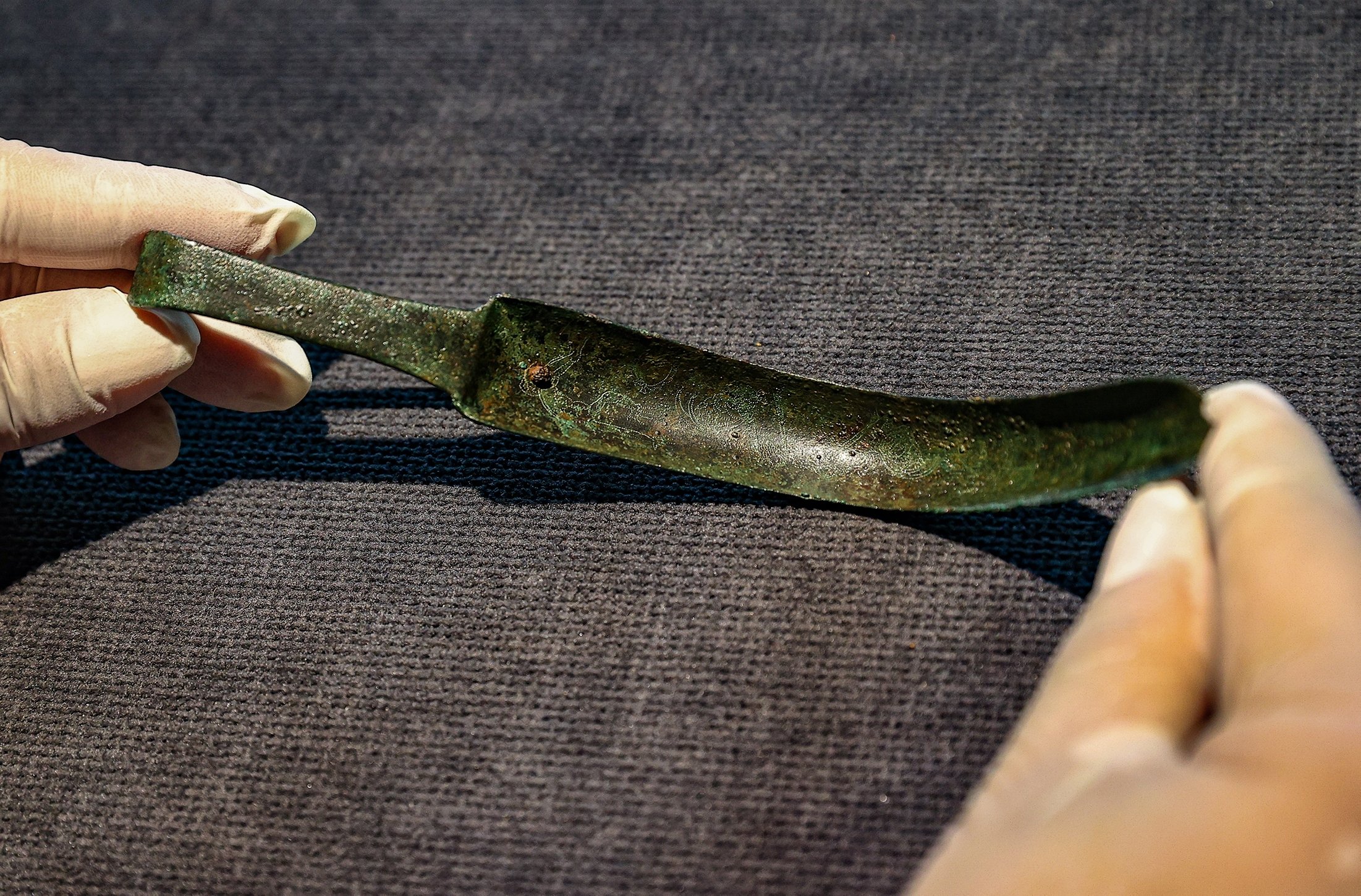 An official presents the ancient artifact known as a "strigil," a historical tool used for cleansing gladiators, on exhibition at Izmir Archaeological Museum in Izmir, Turkey, July 15, 2021. (AA Photo)