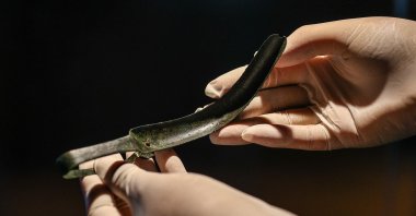 An official presents the ancient artifact known as a "strigil," a historical tool used for cleansing gladiators, on exhibition at Izmir Archaeological Museum in Izmir, Turkey, July 15, 2021. (AA Photo)