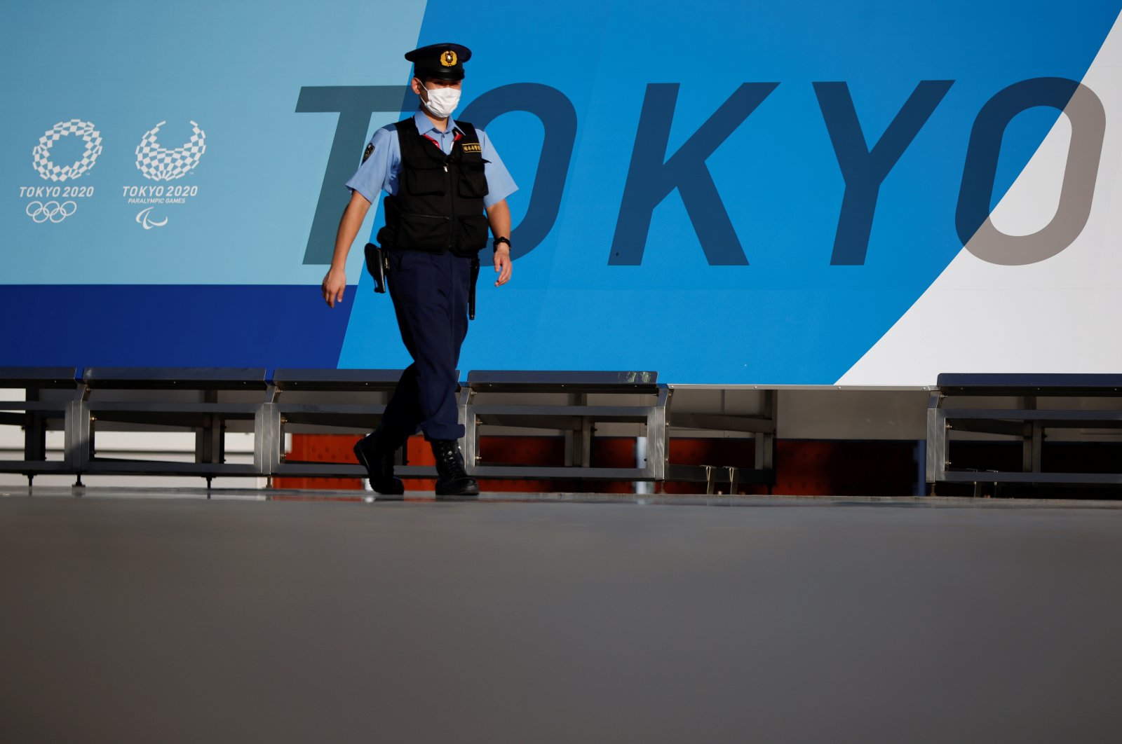 A police officer wearing a face mask walks past Tokyo 2020 Olympic Games signage at the Main Press Center during the coronavirus outbreak in Tokyo, Japan, July 16, 2021. (Reuters Photo)