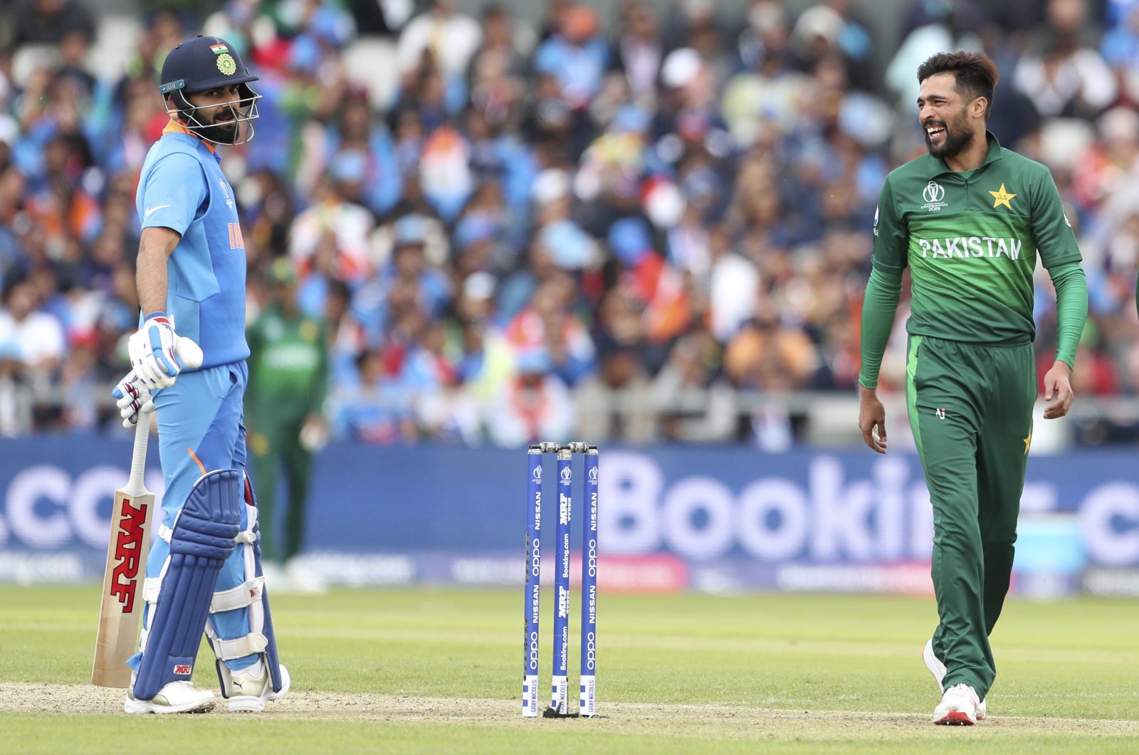 Pakistan's Mohammad Amir (R) gestures toward India's captain Virat Kohli during a Cricket World Cup match at Old Trafford in Manchester, England, June 16, 2019. (AP Photo)