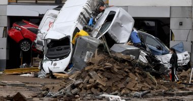 A woman looks at cars and rubble piled up in a street after the floods caused major damage in Bad Neuenahr-Ahrweiler, western Germany, July 16, 2021. (AFP Photo)