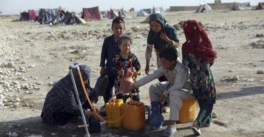 Internally displaced Afghans, who fled their home due to fighting between the Taliban and Afghan security personnel, fill water containers from a public water tap at a camp on the outskirts of Mazar-e-Sharif, northern Afghanistan, July 8, 2021. (AP Photo)
