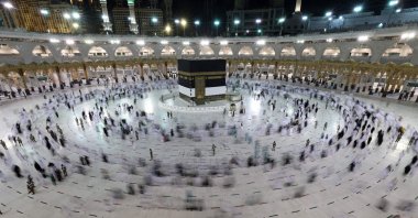 A long exposure photograph shows Muslim pilgrims circumambulating around the Kaaba, Islam's holiest shrine, at the Grand Mosque in the holy Saudi Arabian city of Mecca during the annual hajj pilgrimage, July 17, 2021. (AFP Photo)