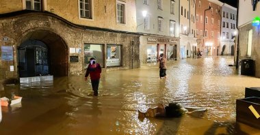 People walk in the flooded historic center, in Hallein, Austria, July 17, 2021. (AFP PHOTO) 