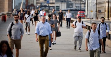 Commuters not wearing facemasks cross London Bridge in London, U.K., July 19, 2021. (AFP Photo)