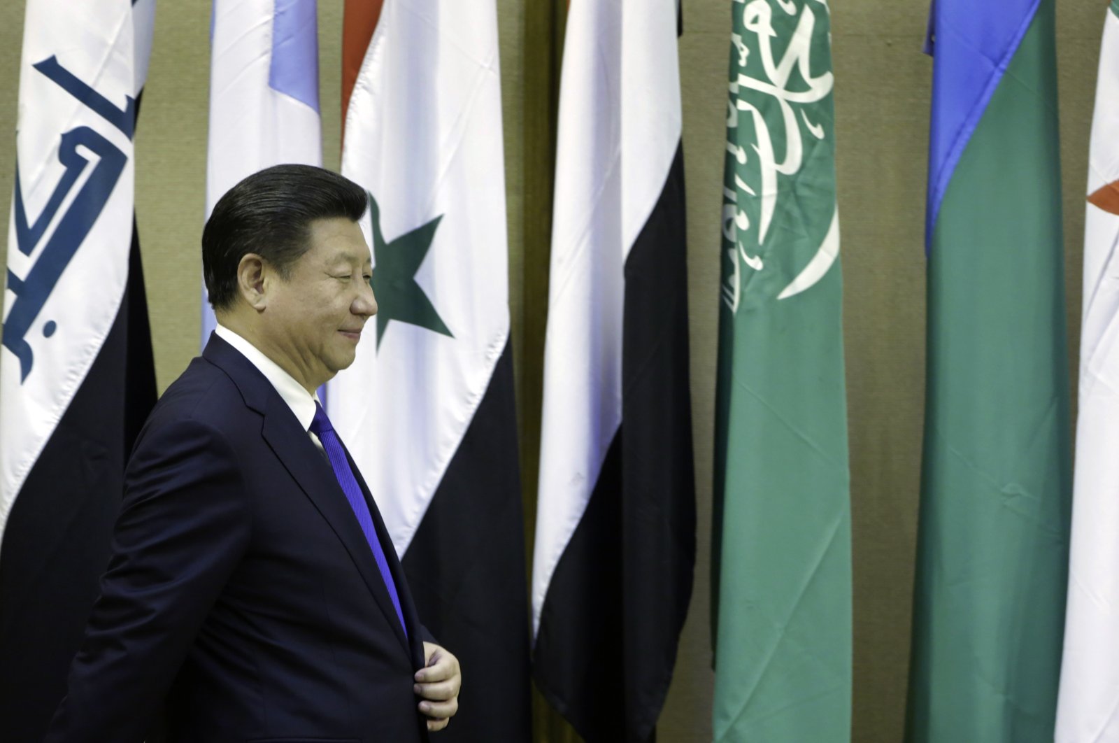 Chinese President Xi Jinping (L) walks in front of flags of Arab countries during his visit to the Arab League headquarters in Cairo, Egypt, Jan. 21, 2016. (AP Photo/Amr Nabil)