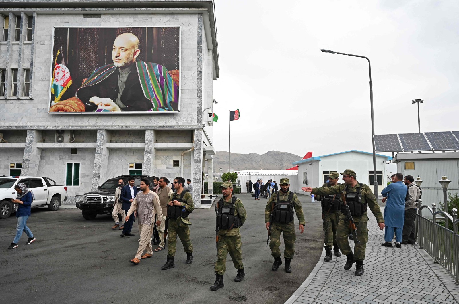 Security personnel walk past a poster of former Afghan President Hamid Karzai at the Hamid Karzai International Airport in Kabul, Afghanistan, July 16, 2021. (AFP Photo)
