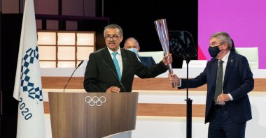 World Health Organization (WHO) Director-General Tedros Adhanom Ghebreyesus (L) receiving the Olympic torch from International Olympic Committee (IOC) President Thomas Bach during the second day of a IOC Session in Tokyo, Japan, July 21, 2021. (AFP Photo)
