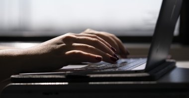 A woman types on her laptop on a train in New Jersey, U.S., May 18, 2021. (AP Photo)