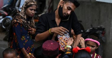 A Rohingya Muslim refugee (C) distributes candy to children during Eid al-Adha, or the Festival of Sacrifice, at a refugee camp on the outskirts of Chennai, India, on July 21, 2021. (AFP Photo)
