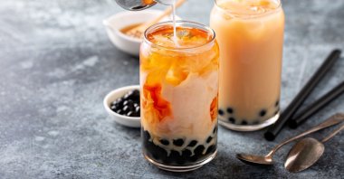 Pouring milk into the bubble tea and seeing it marble into perfection might be the most satisfying part of making your own bubble tea. (Shutterstock Photo)