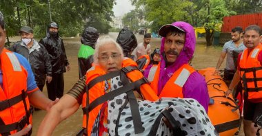 A National Disaster Response Force personnel rescues an elderly woman stranded in floodwaters in Kolhapur, India, July 23, 2021. (AP Photo)