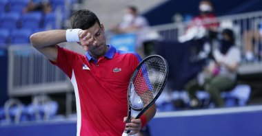 Novak Djokovic of Serbia wipes sweat from his brow as he competes with Hugo Dellien of Bolivia, during the tennis competition at the 2020 Summer Olympics, in Tokyo, Japan, July 24, 2021. (AP Photo)