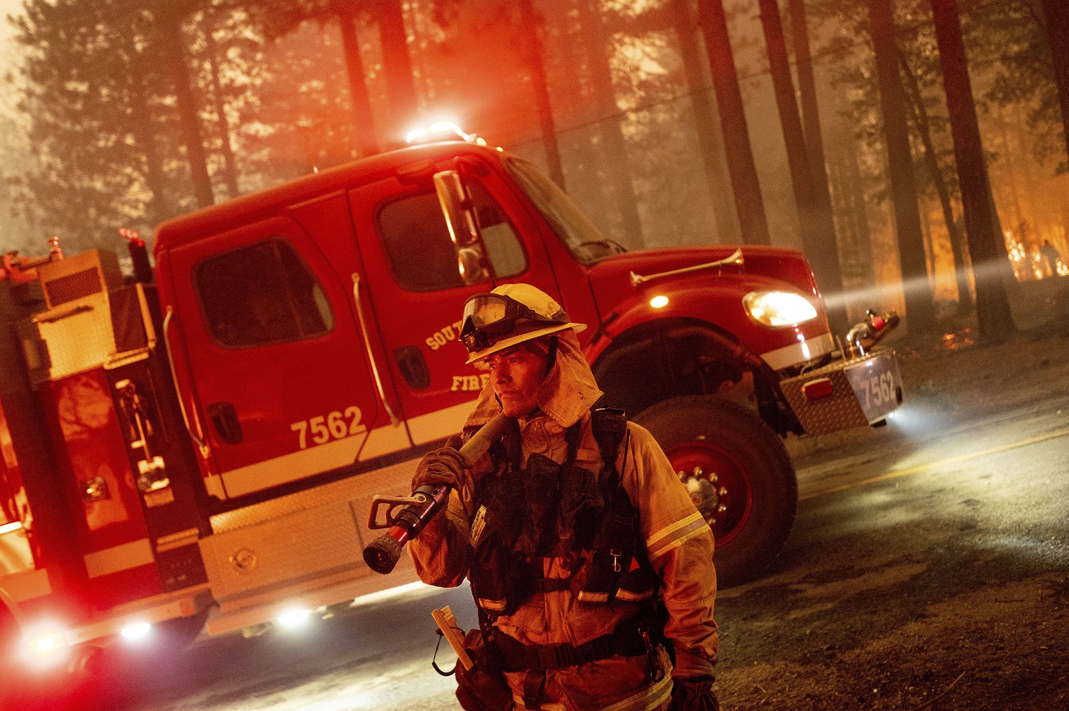 A firefighter prepares to battle the Dixie Fire, which was tearing through the Indian Falls community in Plumas County, California, U.S., July 24, 2021. (AP Photo)