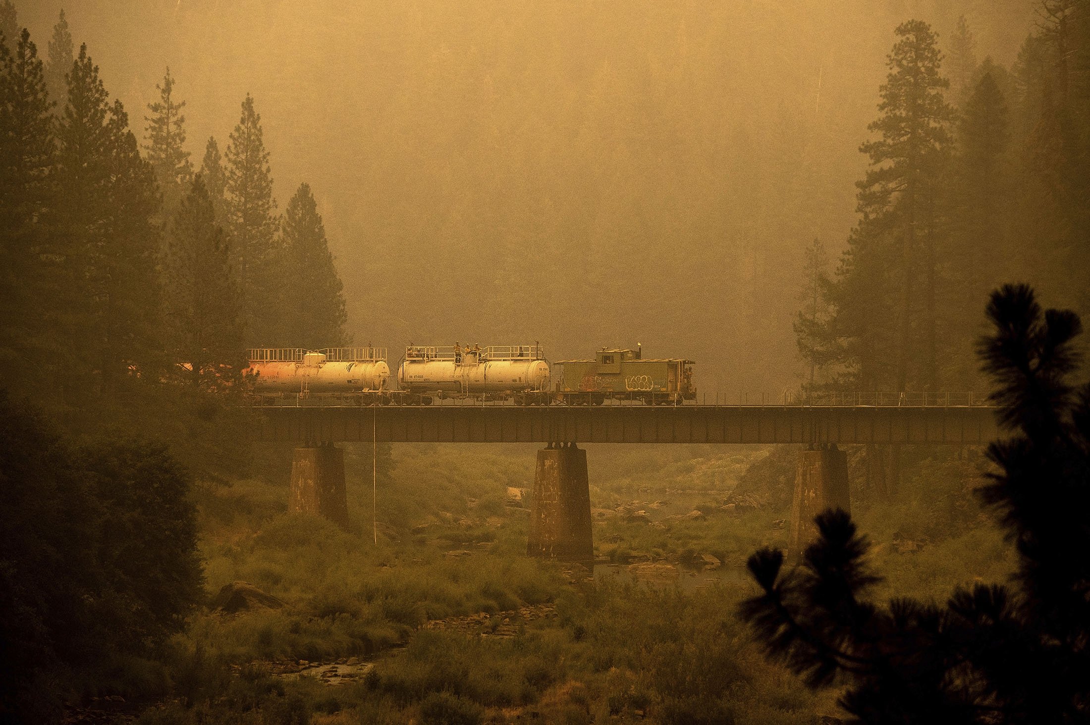 A fire train crosses a bridge as the Dixie Fire burns in Plumas County, California, U.S., July 24, 2021. (AP Photo)