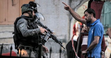 A Palestinian man argues with Israeli border guards blocking a street for a procession of Israelis on Tisha B'Av marching towards the shrine of Atnaeil Ben Kinaz in the flashpoint city of Hebron in the occupied West Bank, Palestine, June 18, 2021. (AFP Photo)