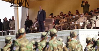 Iraqi Prime Minister Mustafa al-Kadhimi (C) stands while popular Mobilization Forces parade in Diyala, Iraq, June 26, 2021. (AP Photo)