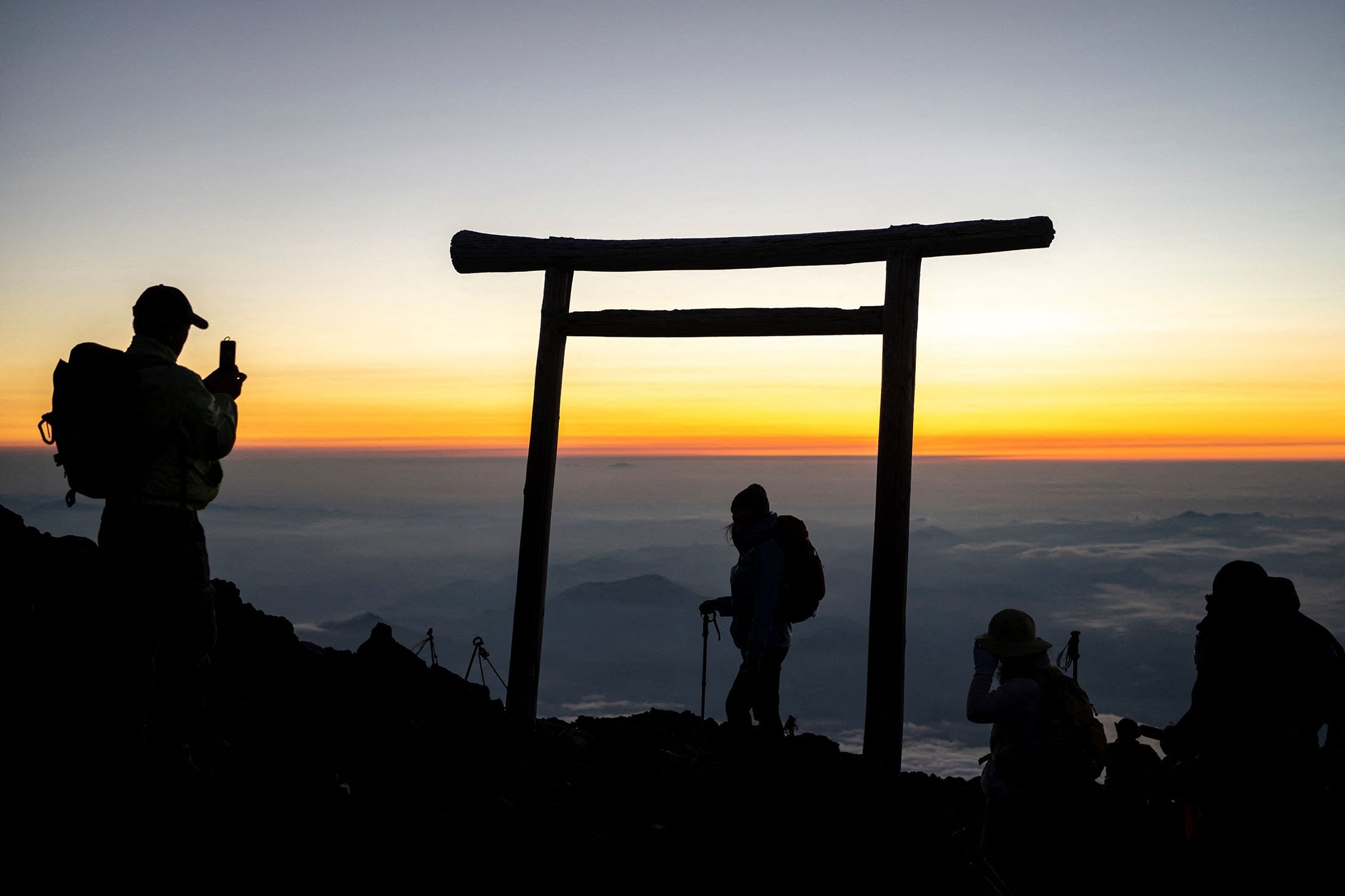 People watch the sunrise from the summit of Mount Fuji, some 70 kilometers (43 miles) west of the capital Tokyo, Japan, July 19, 2021. (AFP Photo)