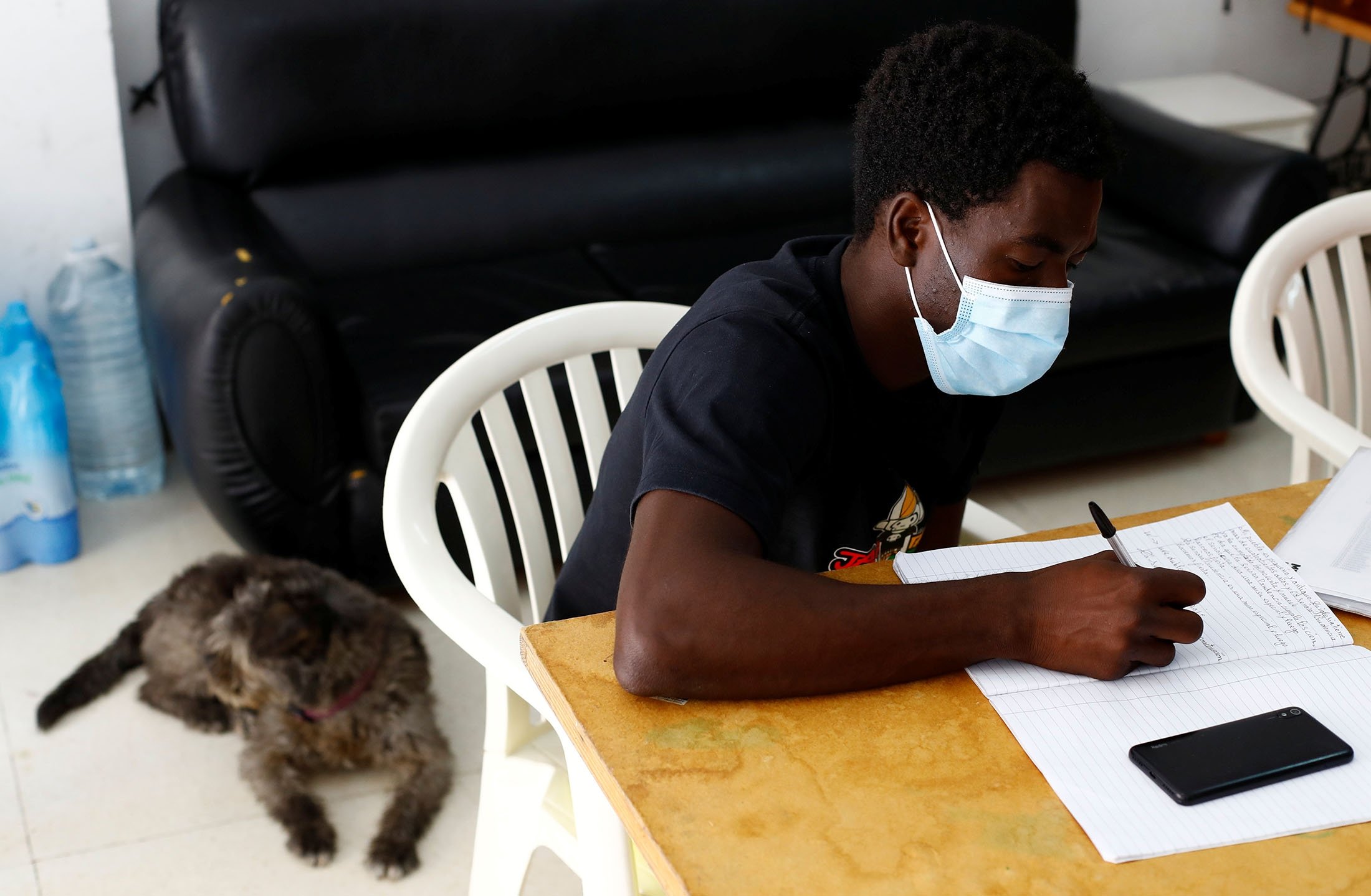 Mohamed Gueye, a Senegalese migrant who arrived on the island in a boat, receives Spanish lessons in Tito Martin