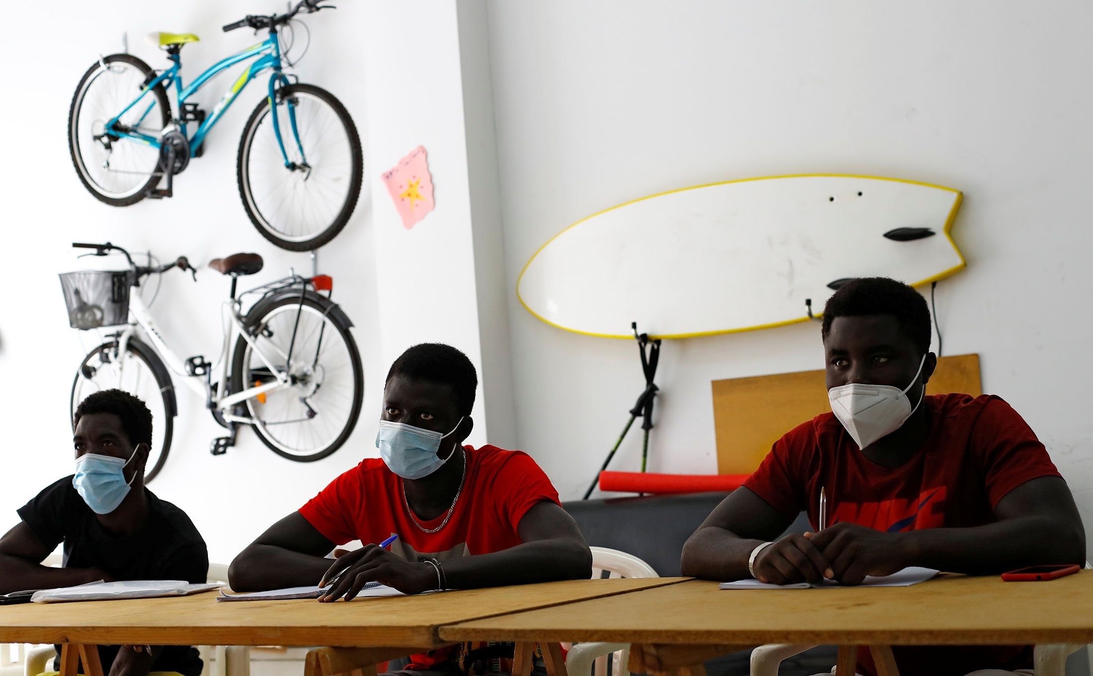Mohamed Gueye (L), Mor Low (C) and Ali Thiam, migrants from Senegal, take Spanish lessons in Tito Martin