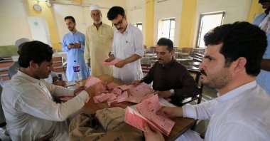 Polling officers count ballots at a polling station in Peshawar, Pakistan, July 25, 2021. (EPA Photo)