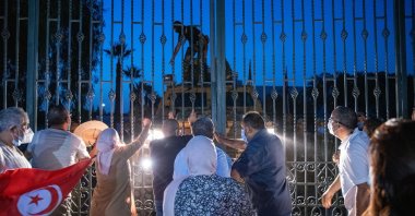 Supporters of the Ennahdha party stand at the gates of the parliament, protesting the drastic political move as a coup, July 26, 2021. (AA Photo)
