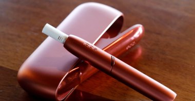 The charger and the holder (top) of the electric tobacco heating system IQOS of cigarette maker Philip Morris Switzerland are displayed after a news conference in Bern, Switzerland, Nov. 19, 2019. (Reuters Photo)