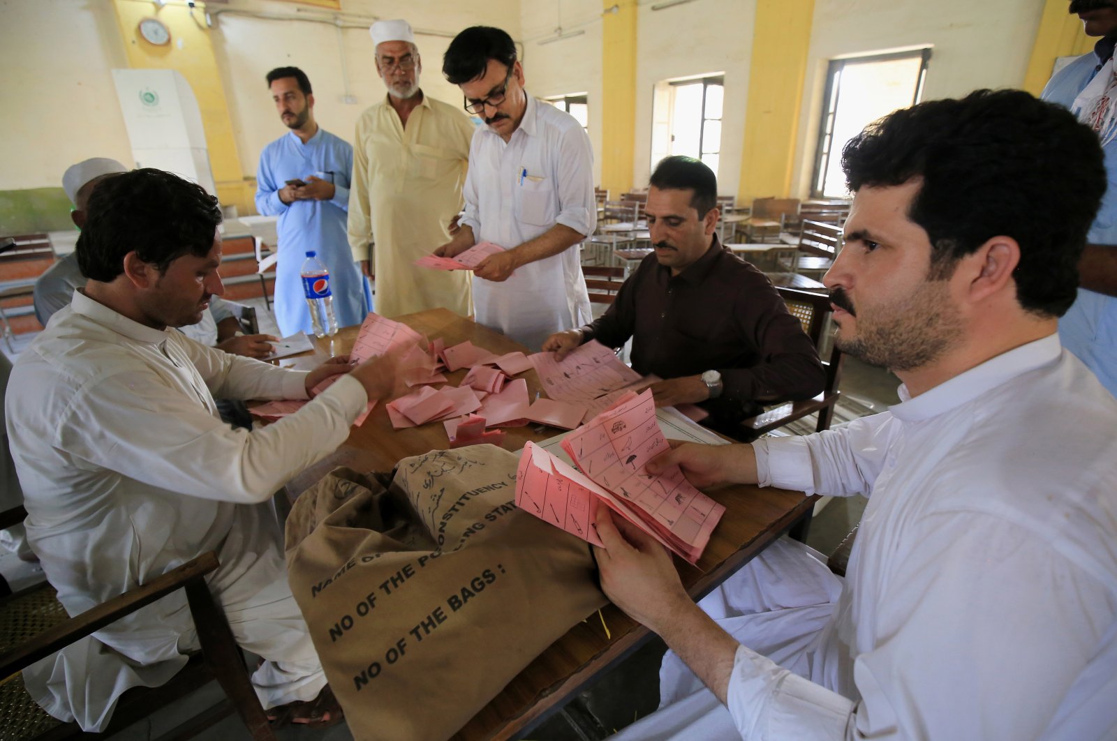 Polling officers count ballots at a polling station in Peshawar, Pakistan, July 25, 2021. (EPA Photo)