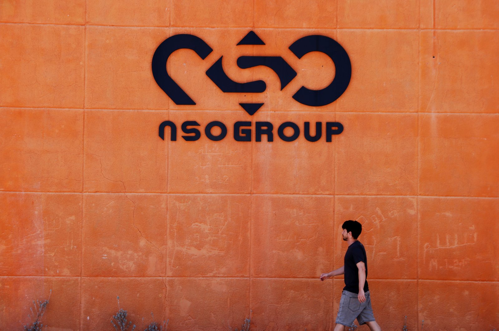 A man walks past the logo of Israeli cyber firm NSO Group at one of its branches in the Arava Desert, southern Israel, July 22, 2021. (Reuters Photo)