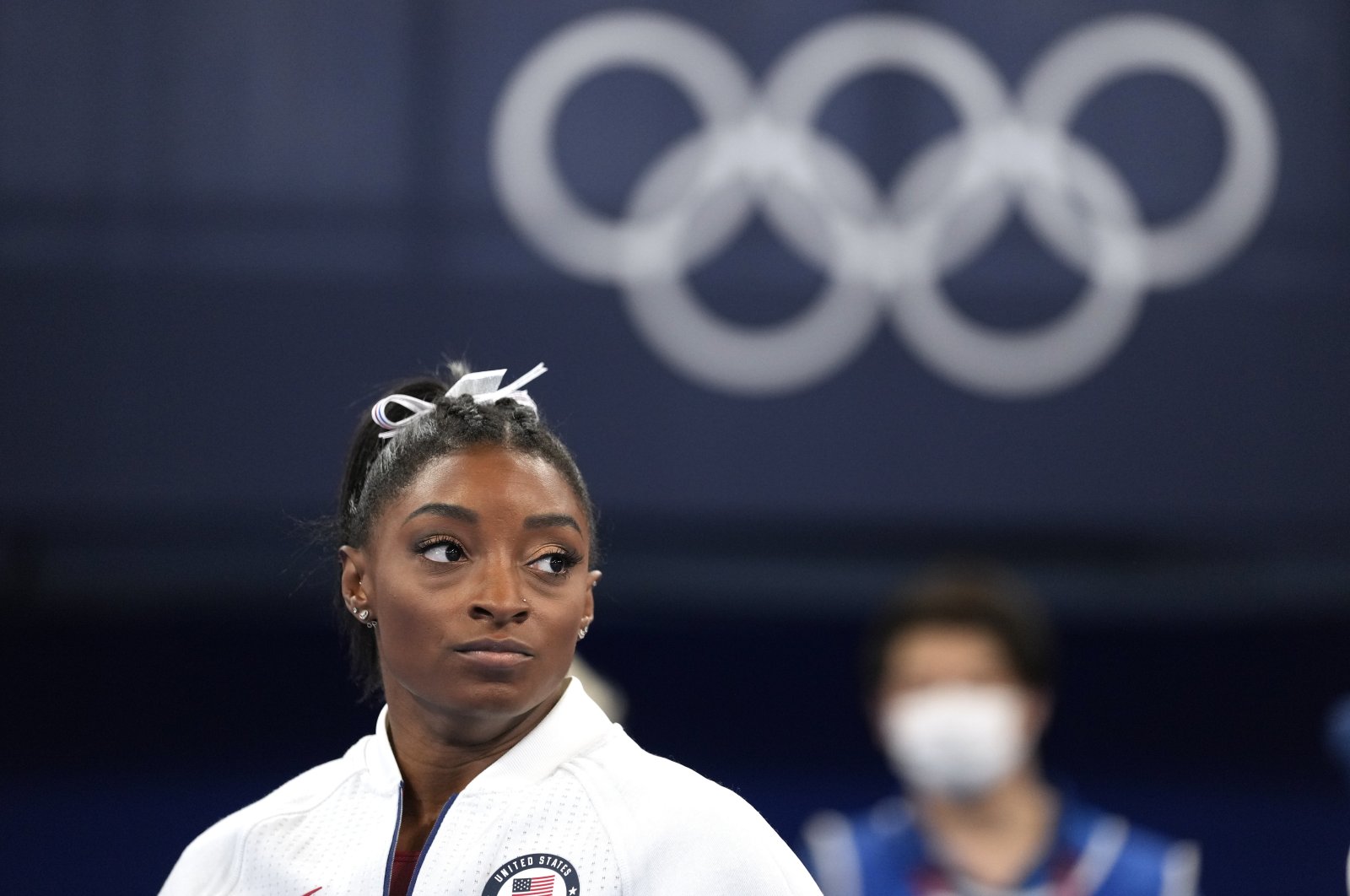 U.S.'s Simone Biles watches gymnasts perform after she exited the team final with an apparent injury, at the 2020 Summer Olympics, Tokyo, Japan, July 27, 2021. (AP Photo)
