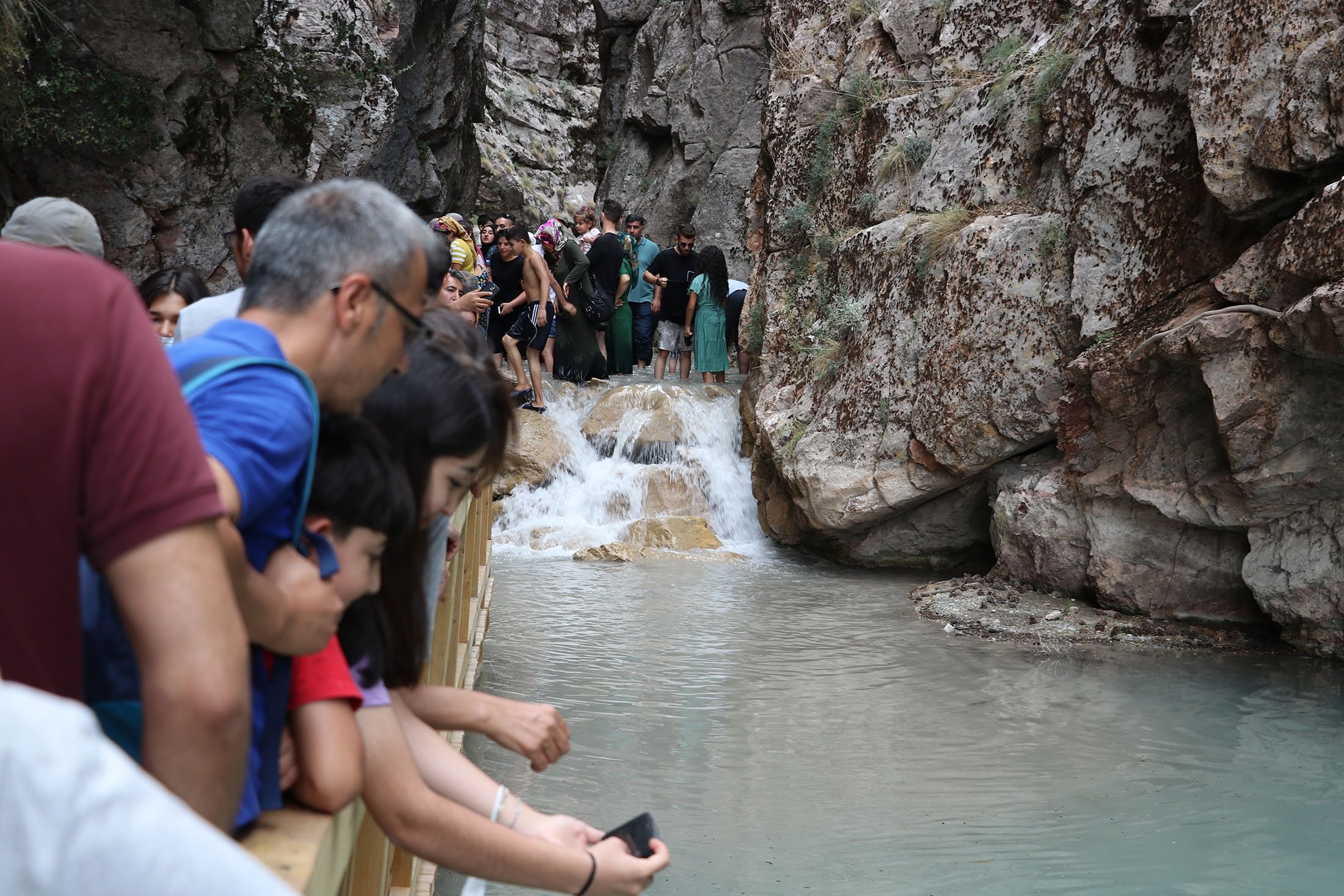People walk along a wooden platform and watch the water flow at the Acıpayam Canyon, Denizli, Turkey, July 25, 2021. (AA Photo)