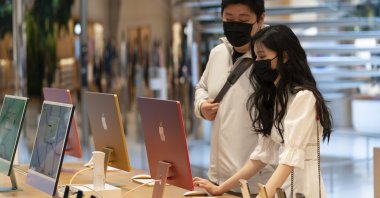 Customers view the new 24" iMac desktop computers in an Apple store, in New York, U.S., May 21, 2021. (AP Photo) 