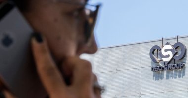 A woman uses her phone in front of the building housing the Israeli company NSO Group, in Herzliya, near Tel Aviv, Israel, Aug. 28, 2016. (AFP Photo)