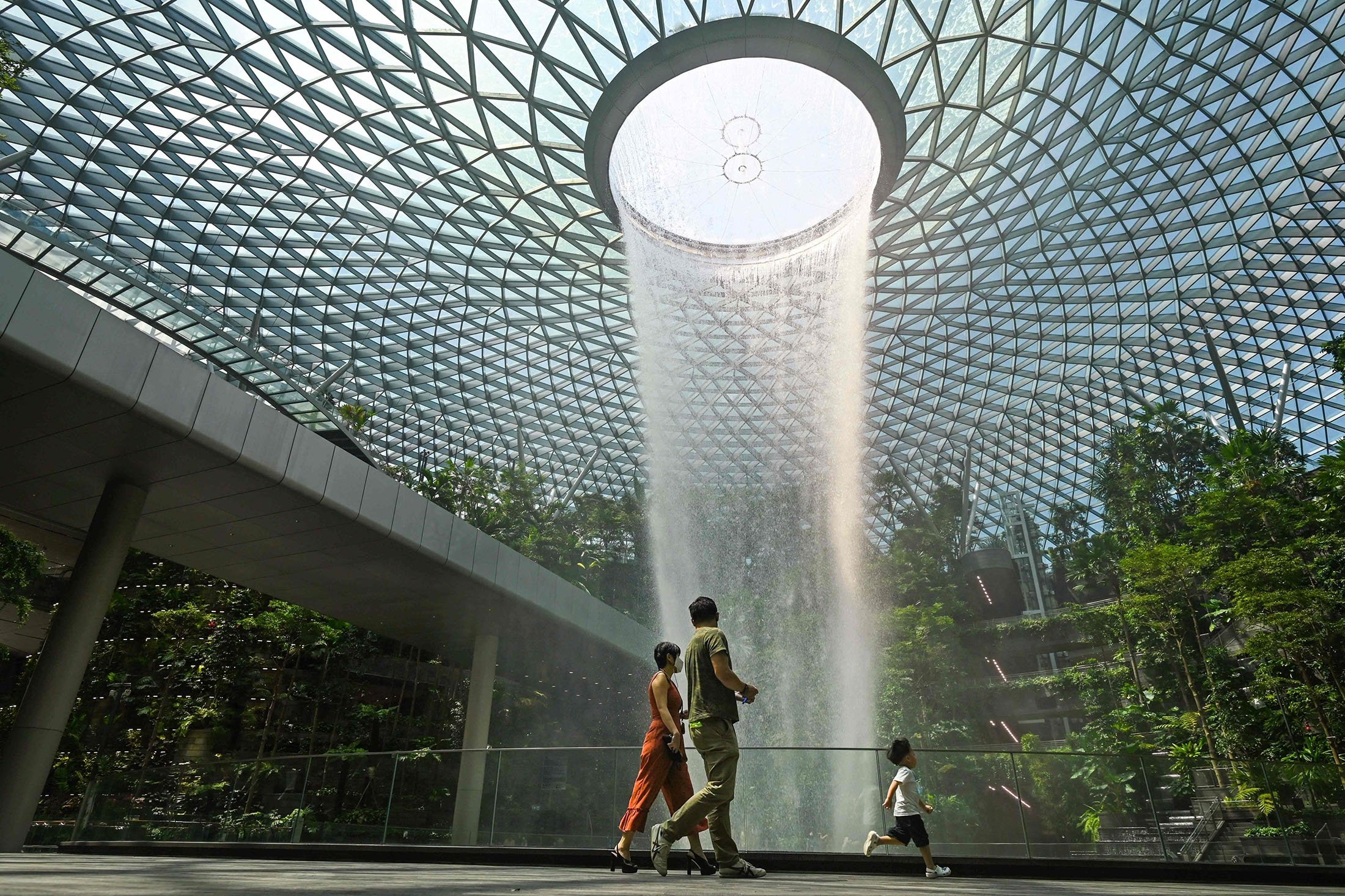A family walks past the rain vortex at Jewel Changi Airport in Singapore, June 23, 2021. (AFP Photo)