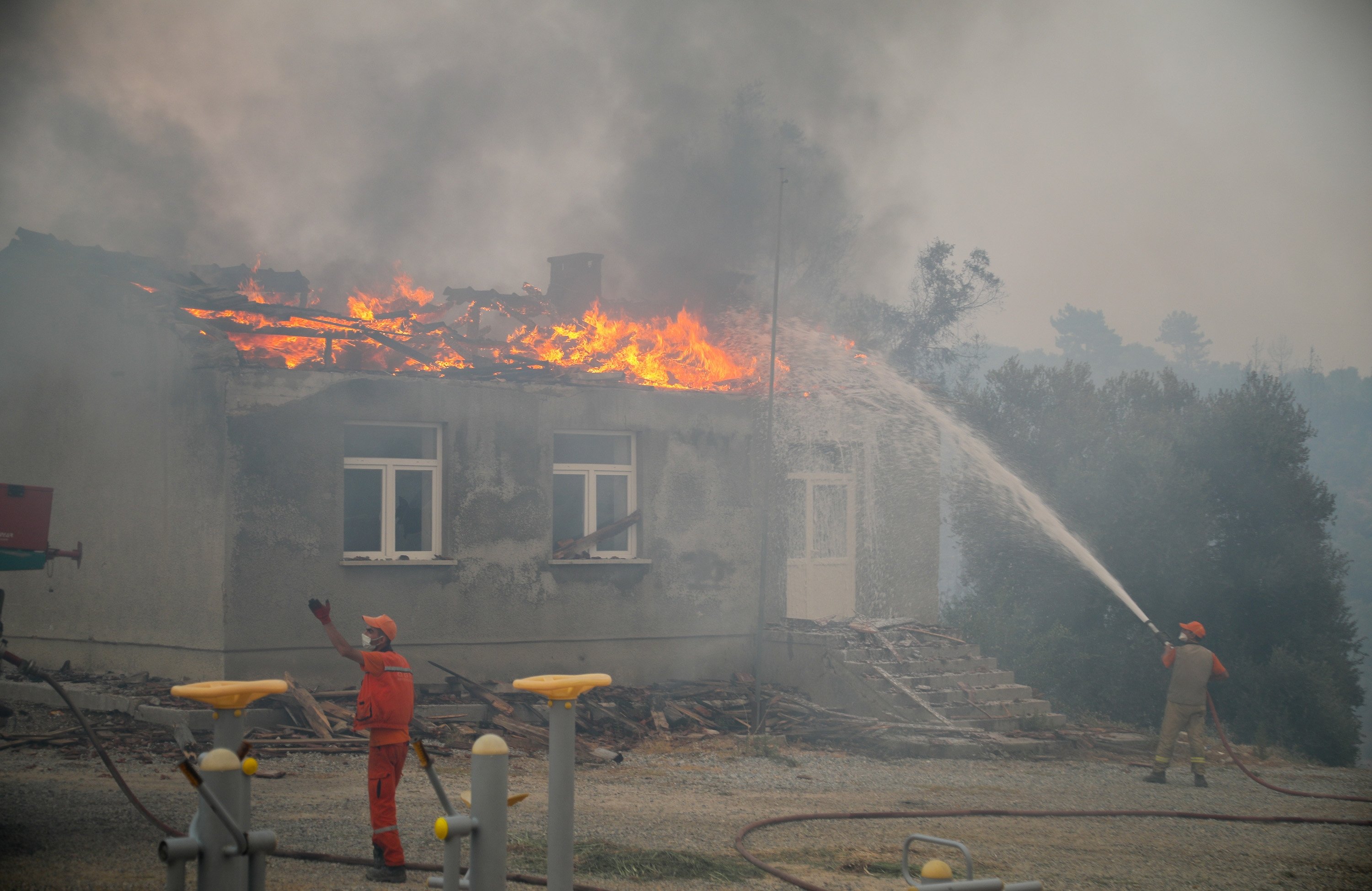 Firefighters try to contain the fire spreading to residential areas in the Manavgat district of Antalya, southern Turkey, July 29, 2021. (DHA Photo)